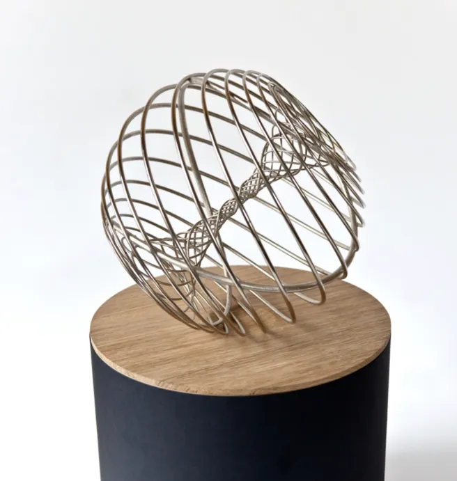 Color photo of an award with a globe made of metal strips and a base of wood