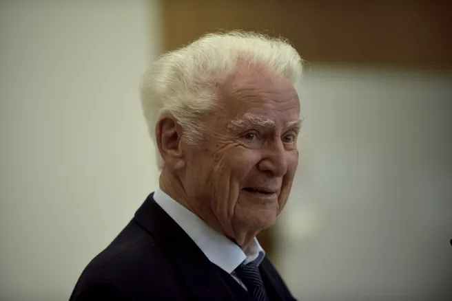 Color photo of a smiling person looking right