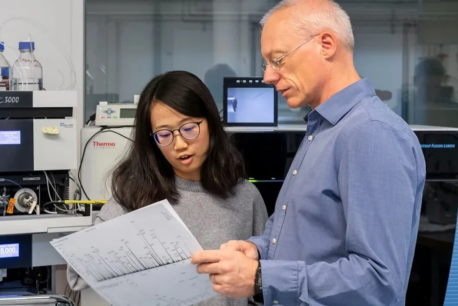 Two scientists discuss a report in the lab