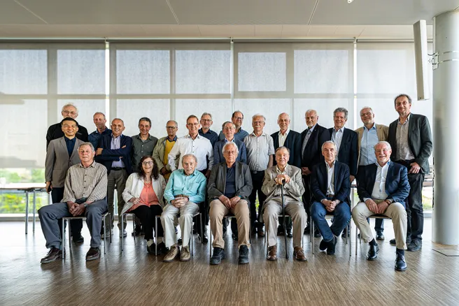 Color photo of a large group of people smiling at the camera