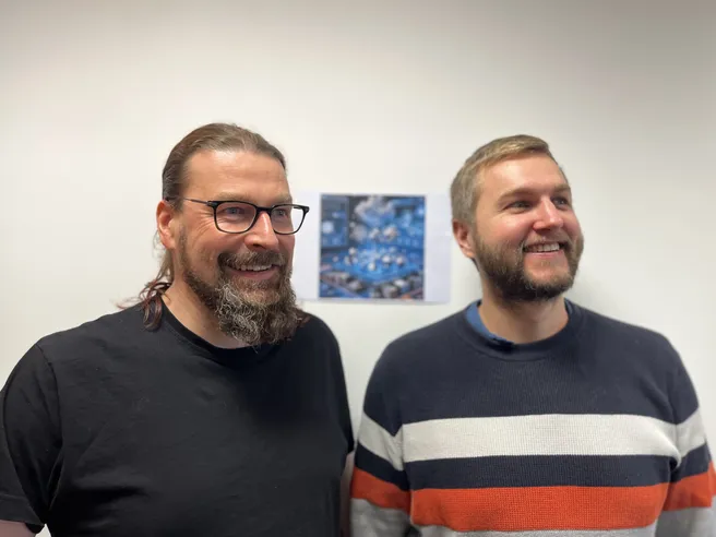 two smiling people look right